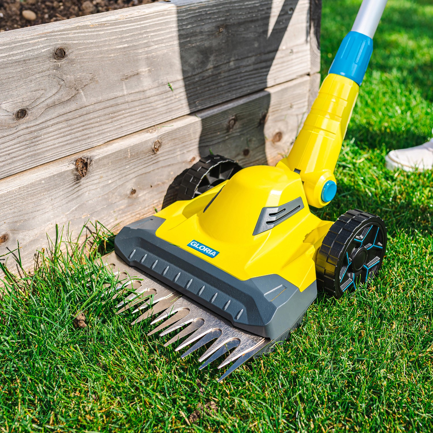 Gelber Gloria Rasen- und Kantenschneider Finecut 18 V im Einsatz am Rasen.