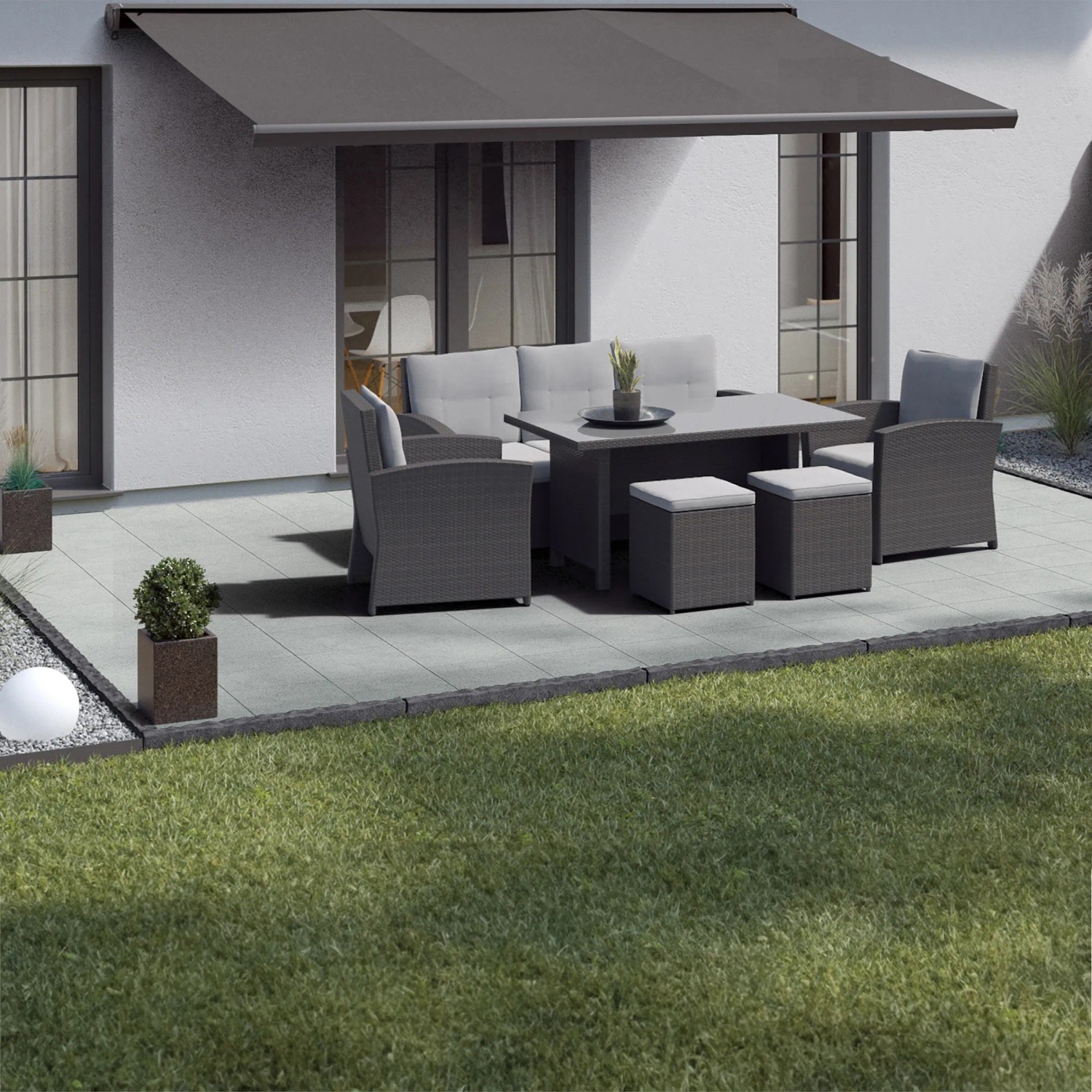 Terrasse mit Betonplatten Mailand weiß-schwarz (40x40) und Gartenmöbeln unter Markise.