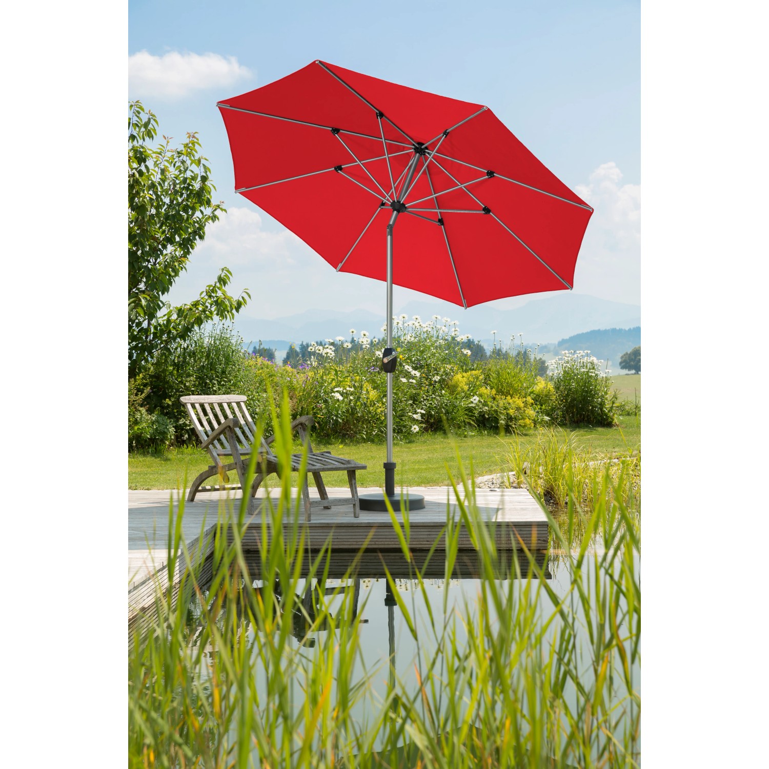 Roter Schneider Marktschirm (Ø 270 cm) mit Kurbel auf Terrasse am Teich.