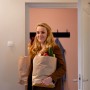 Frau kommt mit Einkäufen nach Hause; WiZ Smart-Sensor für automatische Lichtsteuerung im Hintergrund.
