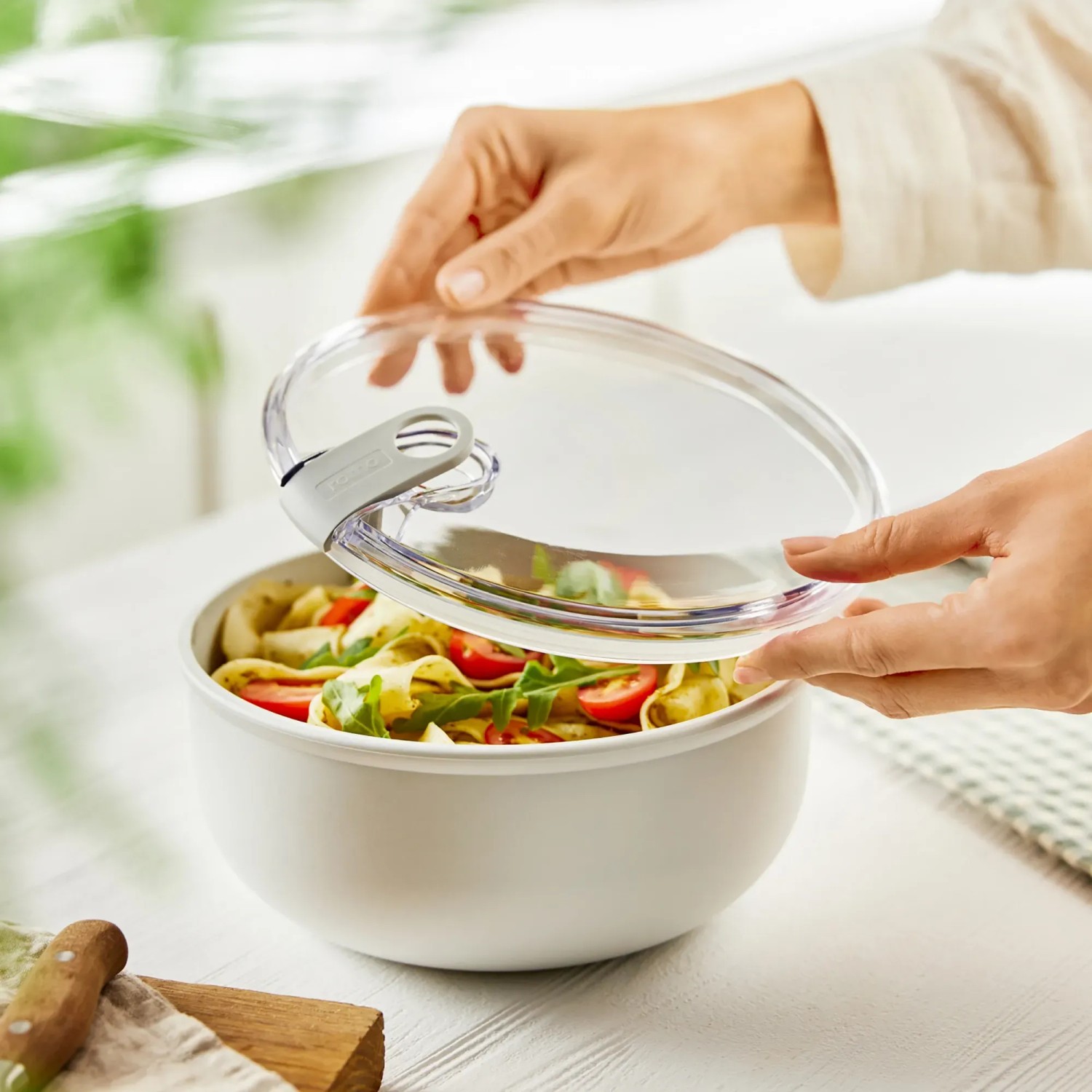 Weiße Rotho Frischhaltedose Ela 1,8 l mit Salat und transparentem Deckel.