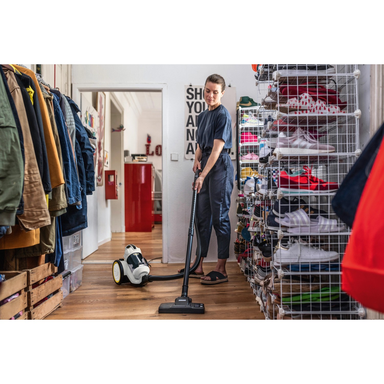 Frau saugt mit Kärcher VC 3 beutellosem Staubsauger Holzboden.