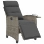 Grauer Poly Rattan Gartensessel mit dunklen Kissen, verstellbarer Fußstütze und integriertem Beistelltisch.