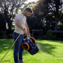 Mann reinigt Segway Navimow Mähroboter i105E mit Wasserschlauch im Garten.
