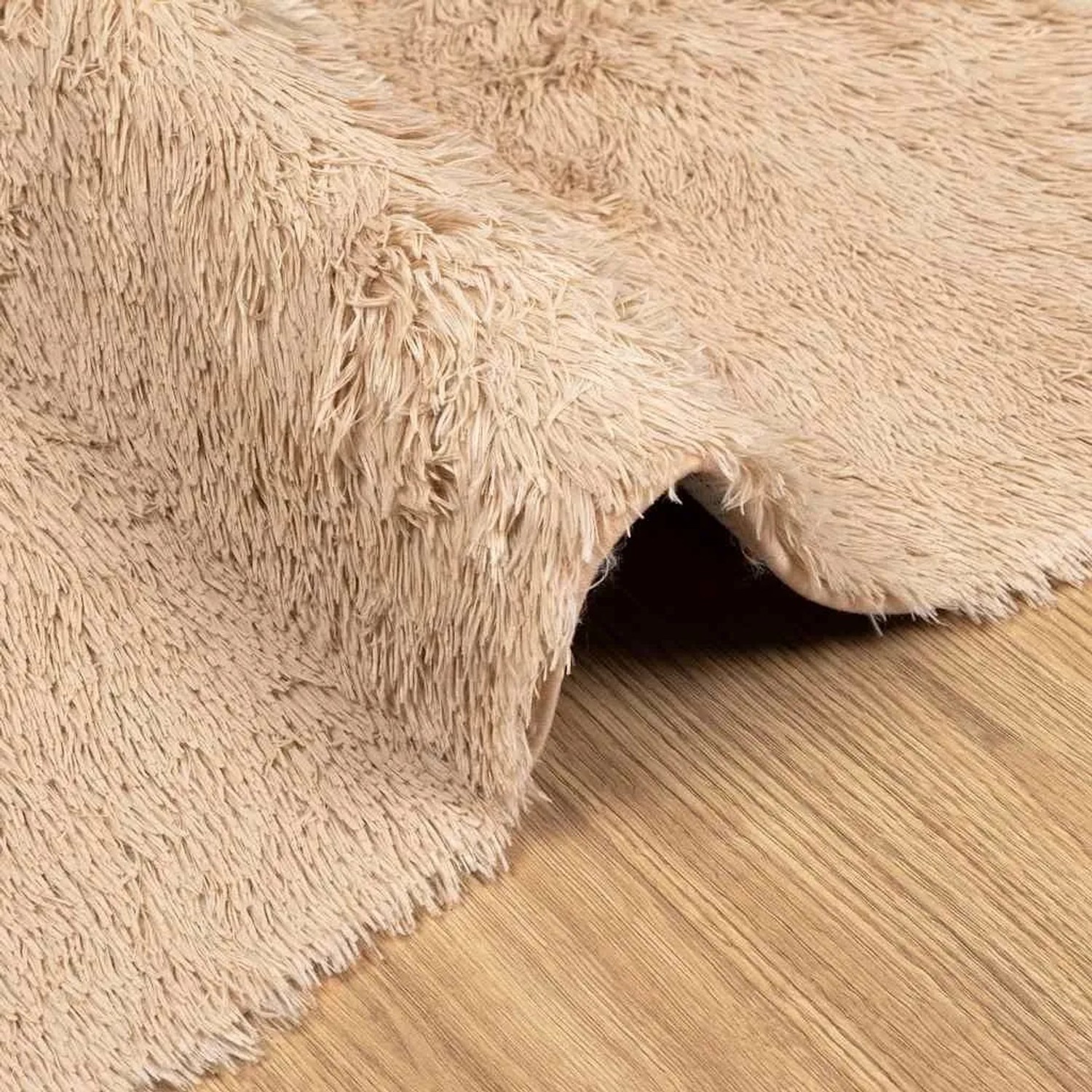Beiger Shaggy Hochflorteppich aus Polyester, mit weichen, langen Fasern, auf Holzfußboden.
