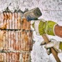 Hände mit Gebol Worker Pro Arbeitshandschuhen Größe 9 beim Stemmen einer Wand mit einem Hammer.