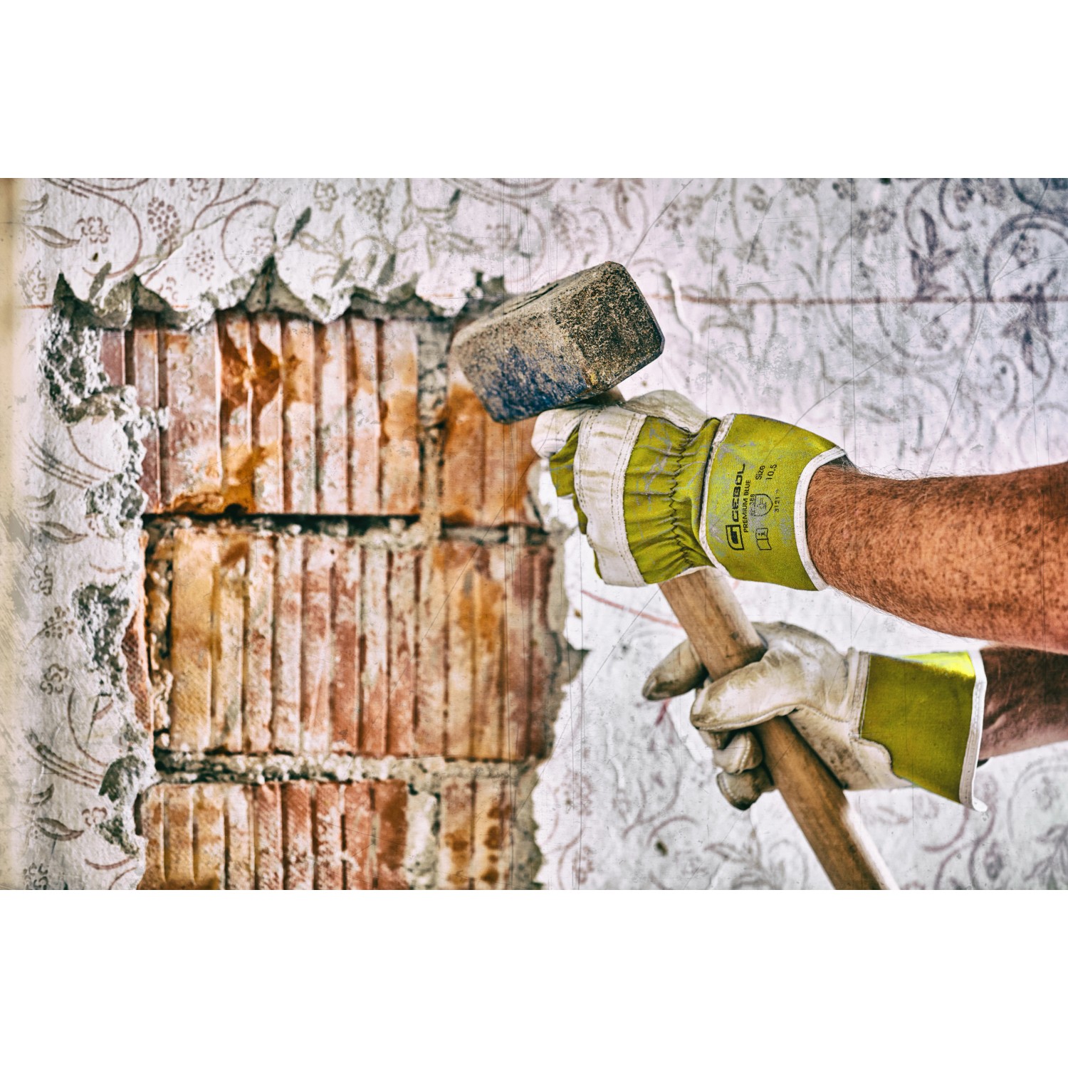 Hände mit Gebol Worker Pro Arbeitshandschuhen Größe 9 beim Stemmen einer Wand mit einem Hammer.