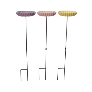 Drei Vogelfutterstellen in Pastellfarben: lila, rosa, gelb. Runde Schalen mit gewelltem Rand auf schwarzen Stäben für den Garten.