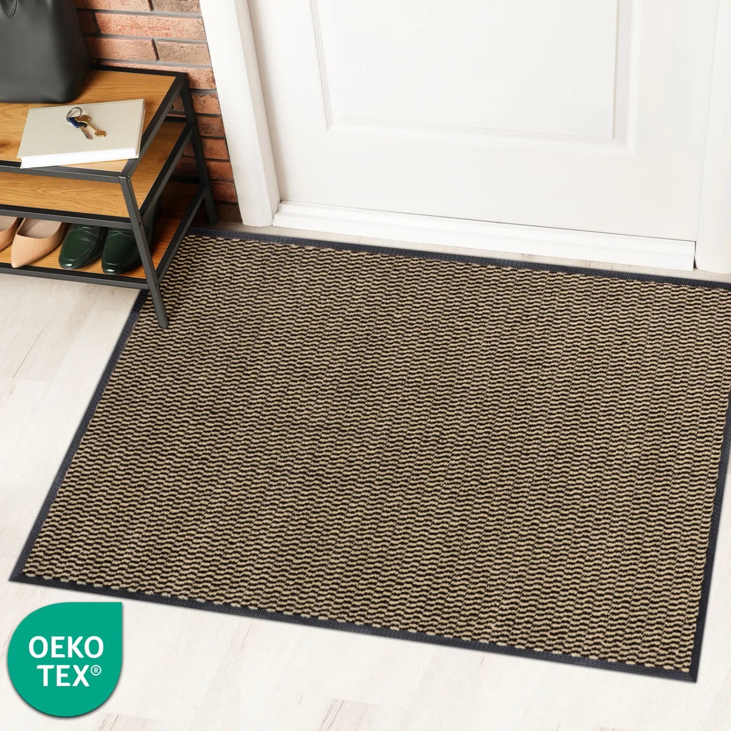 Ocker-schwarze KARAT Schmutzfangmatte SKY Novo (90x150 cm) vor einer Tür.
