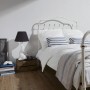 Schlafzimmer mit weißer A.S. Creation Vliestapete OK 6 Uni Weiß FSC® an der Wand.