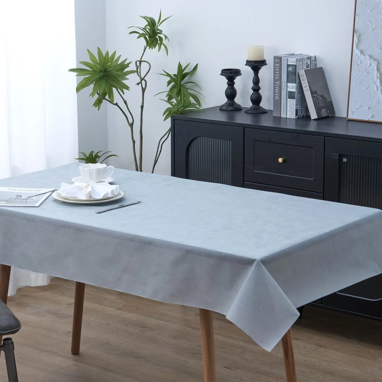 Weiße Vlies-Tischdeckenrolle, 118 cm x 25 m, auf einem gedeckten Tisch. Perfekt für flexible Tischdekoration.