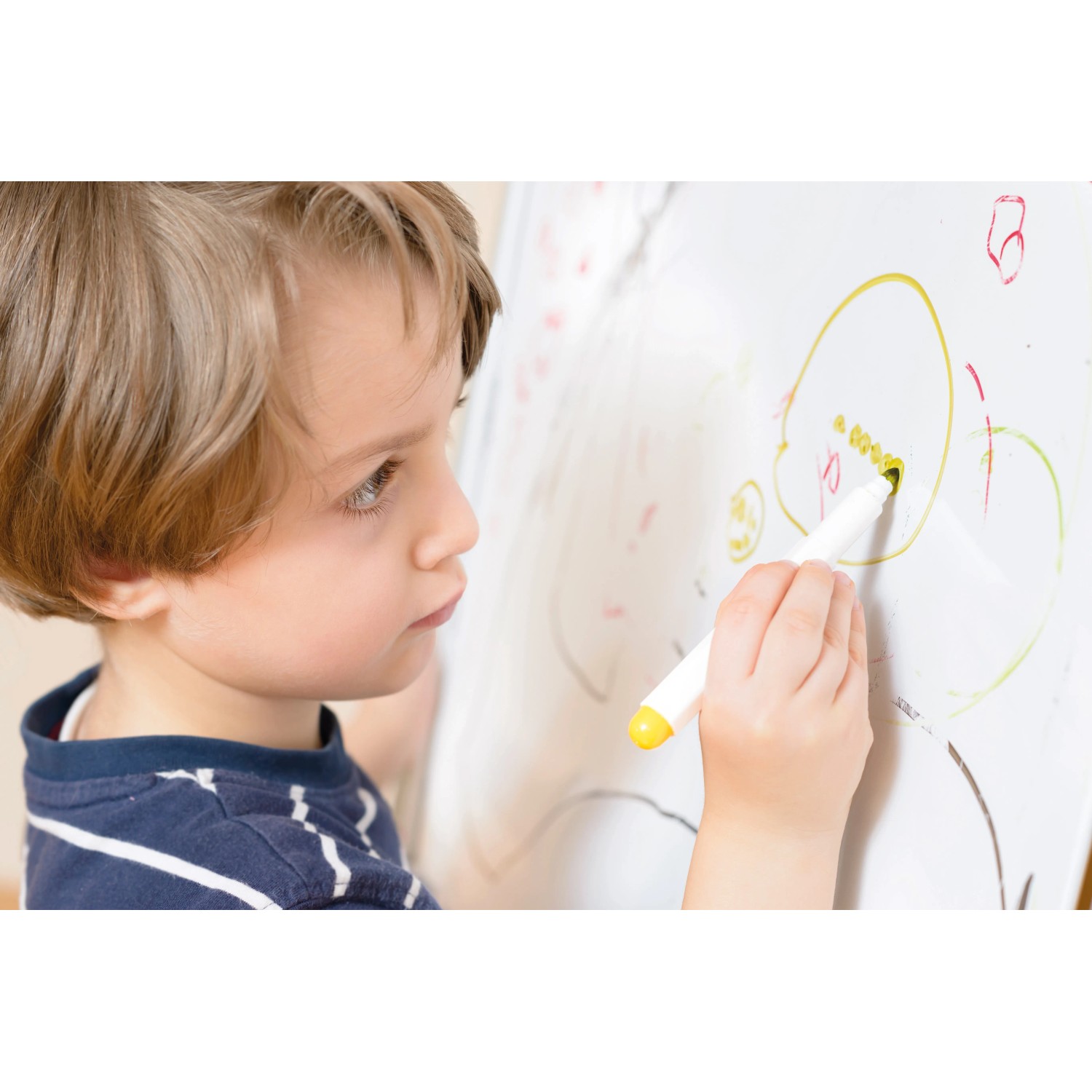 Kind malt mit Stift auf Whiteboard, erstellt mit Rust-Oleum Little Stars Weißtafelkit Winter Wunderland.