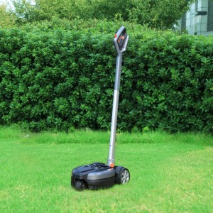 Yard Force Akku-Handmäher iFlex mit Rasentrimmeraufsatz auf Rasen vor grüner Hecke.