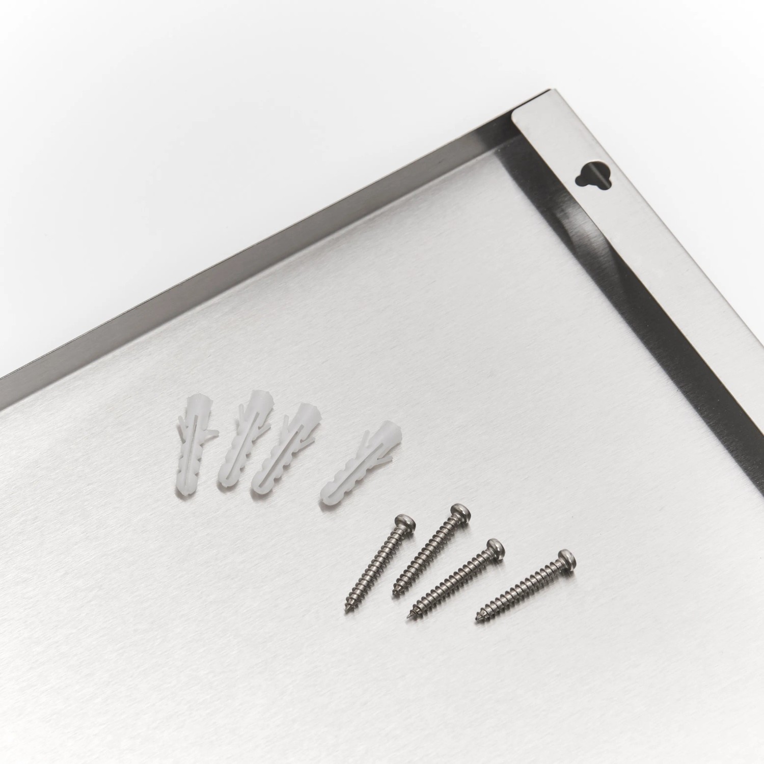 Detailaufnahme der Edelstahl Magnettafel (40x60 cm) von Zeller inklusive Schrauben und Dübel.