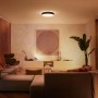 Moderne Philips Hue Enrave L Deckenleuchte in Schwarz, montiert in einem Wohnzimmer.