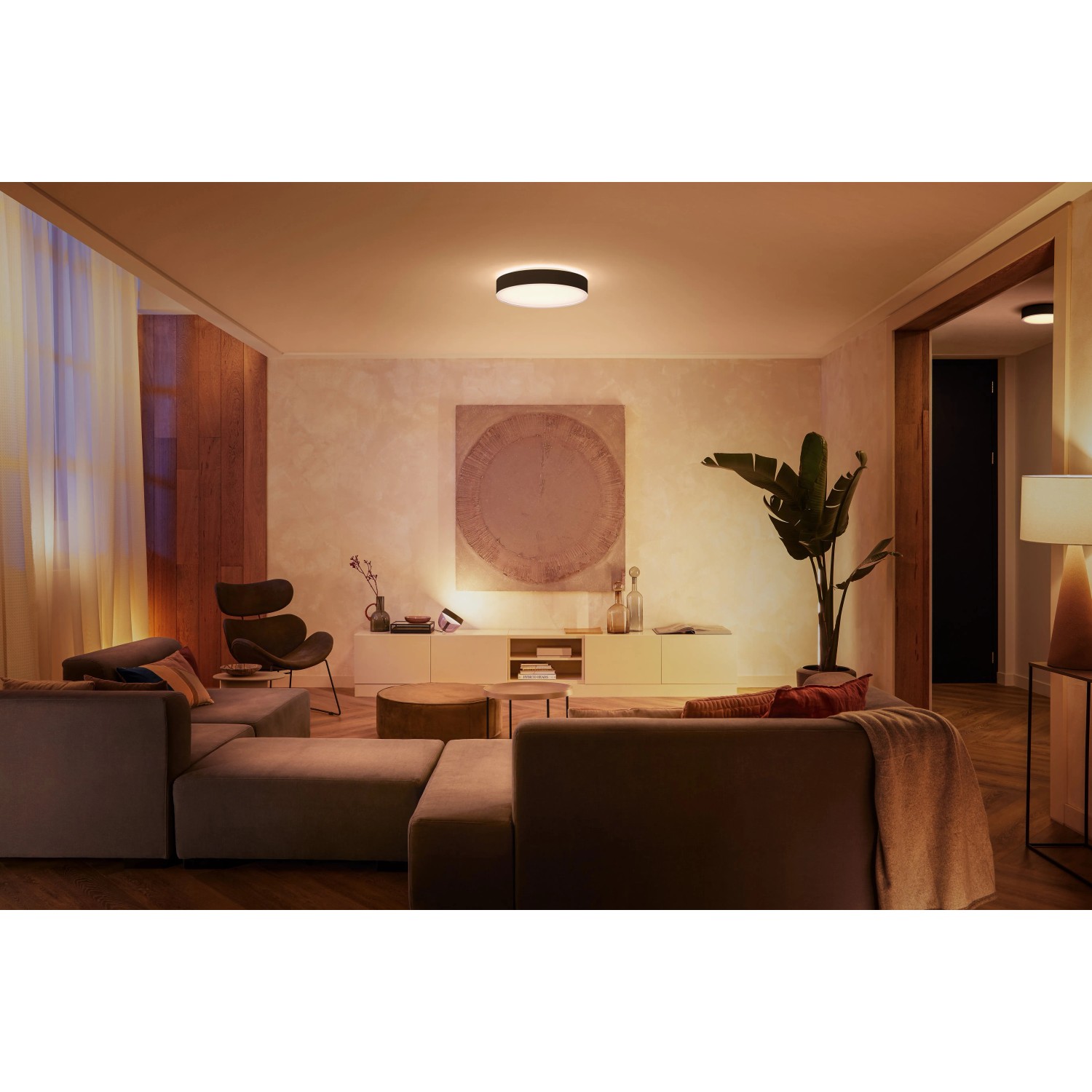 Moderne Philips Hue Enrave L Deckenleuchte in Schwarz, montiert in einem Wohnzimmer.