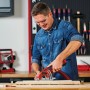 Ein Mann sägt Holz mit der Einhell Mini-Handkreissäge TC-CS 89 in der Werkstatt.