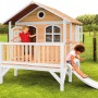 Axi Stef Spielhaus aus Holz in Braun-Weiß mit Rutsche und zwei spielenden Kindern im Garten.