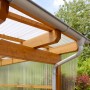 Transparente Acryl-Trapezplatte als Bedachung für eine Holzkonstruktion mit Regenrinne.