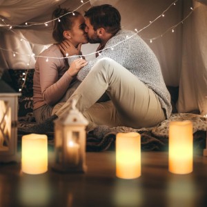 Drei cremefarbene flammenlose LED Echtwachs Kerzen in gemütlicher Atmosphäre. Warmes Licht für Romantik.