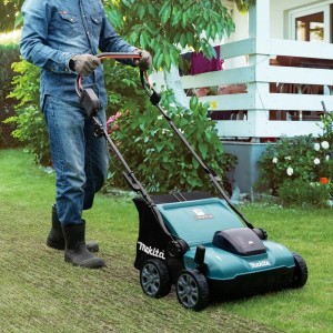 Makita Akku-Vertikutierer DUV320Z in Aktion: Mann vertikutiert Rasen im Garten.