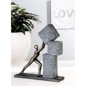 Bronzefarbene Skulptur eines Mannes, der graue, strukturierte Blöcke stapelt. Moderne Dekorative Figur aus Kunstharz.