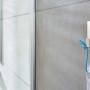 Tesa Powerstrips Haken Waterproof eckig Edelstahl Large an grauer Wand mit aufgehängtem Gegenstand.