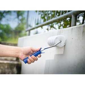Hand streicht mit LUX-TOOLS PRO Farbwalze (18 cm) eine Wand. Farbroller für Lacke.