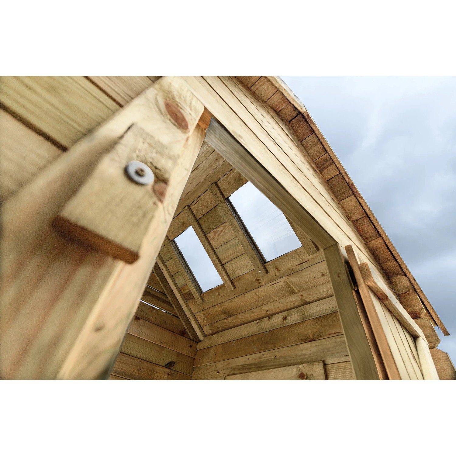 Innenansicht SwingKing Spielhaus Louise mit Dachfenstern und Holzwänden.