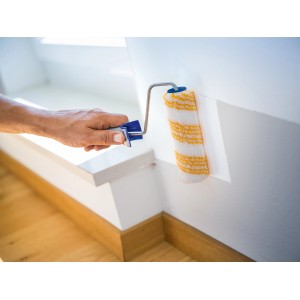 LUX Dispersionsroller 15cm beim Streichen einer Wand. Farbwalze mit Polyamid-Bezug und gold-gestreiften Muster.