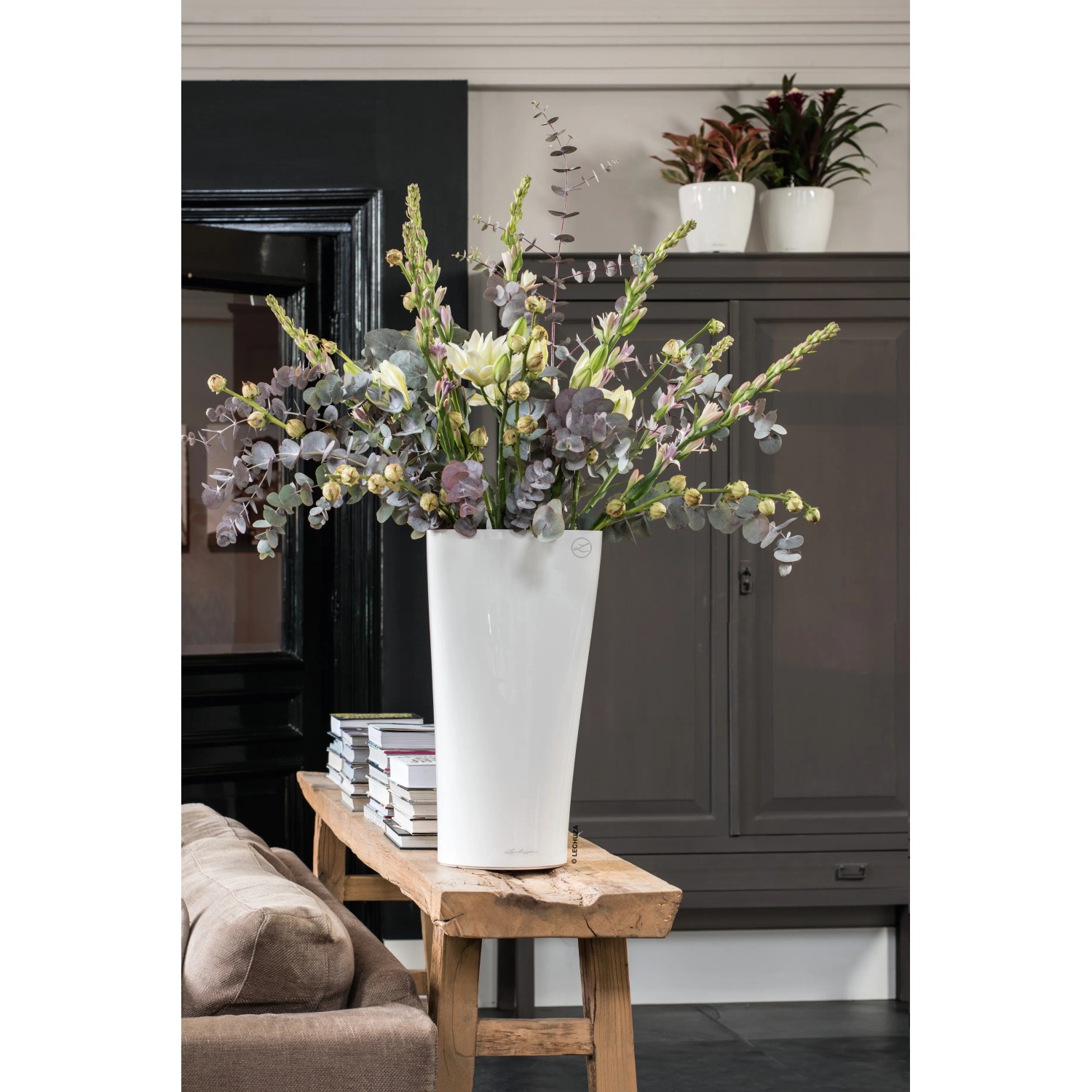 Weiße Lechuza Delta Premium Pflanzsäule (40x40x75cm) mit Blumenarrangement.