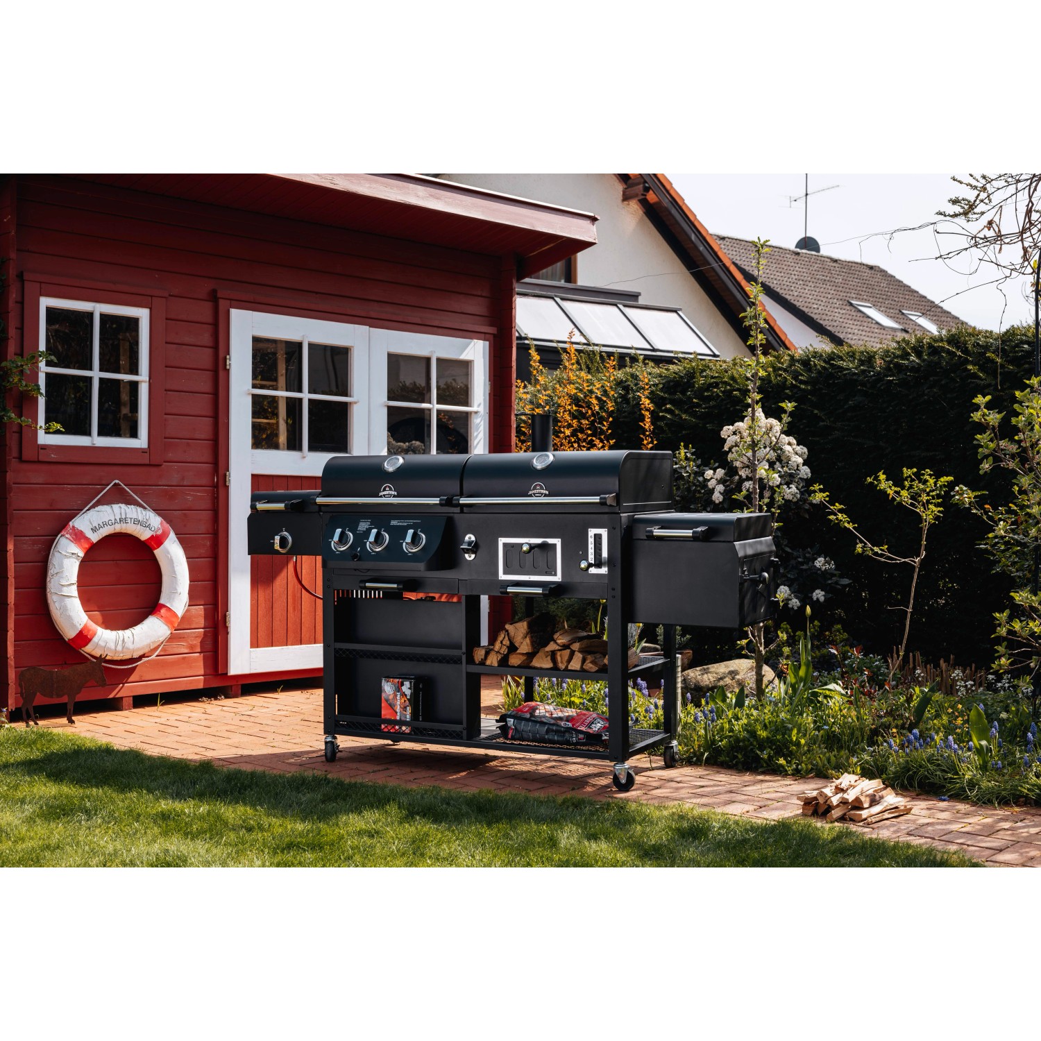 Schwarzer Jamestown Kombigrill Drake im Garten mit Gas-, Holzkohle- und Smoker-Funktion.