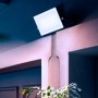 Quadratischer, schwarzer Philips LED-Außenstrahler Lois mit hellem, weißem Licht an einer Wand.