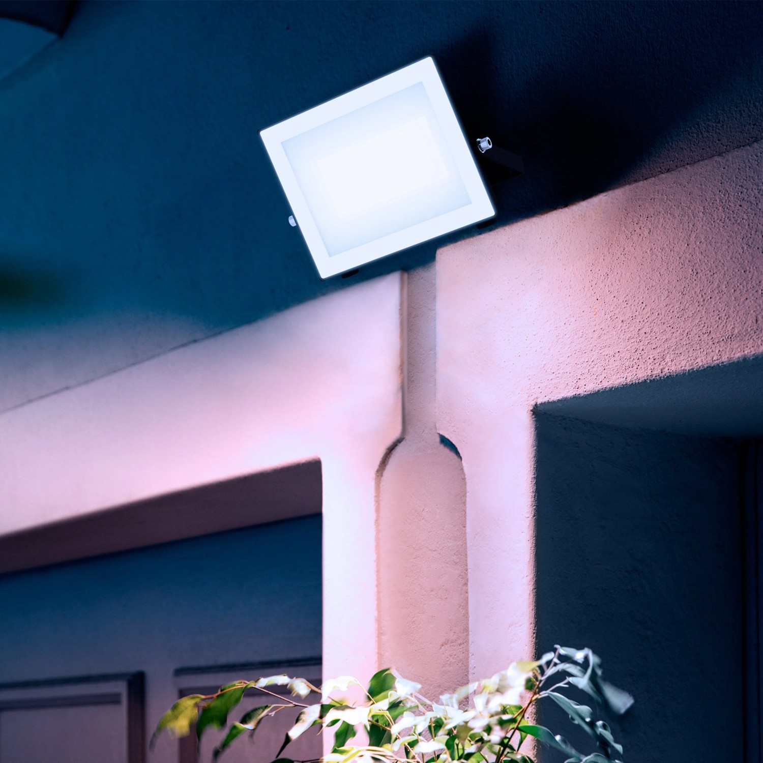Quadratischer, schwarzer Philips LED-Außenstrahler Lois mit hellem, weißem Licht an einer Wand.