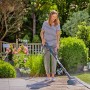 Frau reinigt Terrasse mit Gardena Akku-Multi-Reiniger AquaBrush Patio inkl. Akku.