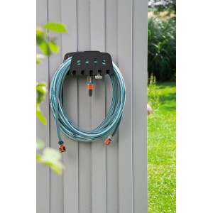 Gardena Wandschlauchhalter mit Schlauch an grauer Wand. Praktische Gartenschlauch Aufbewahrung.
