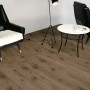 Verlegter, dunkler Laminatboden Comfort Walnuss Tobacco mit Möbeln in Wohnraum-Szene.