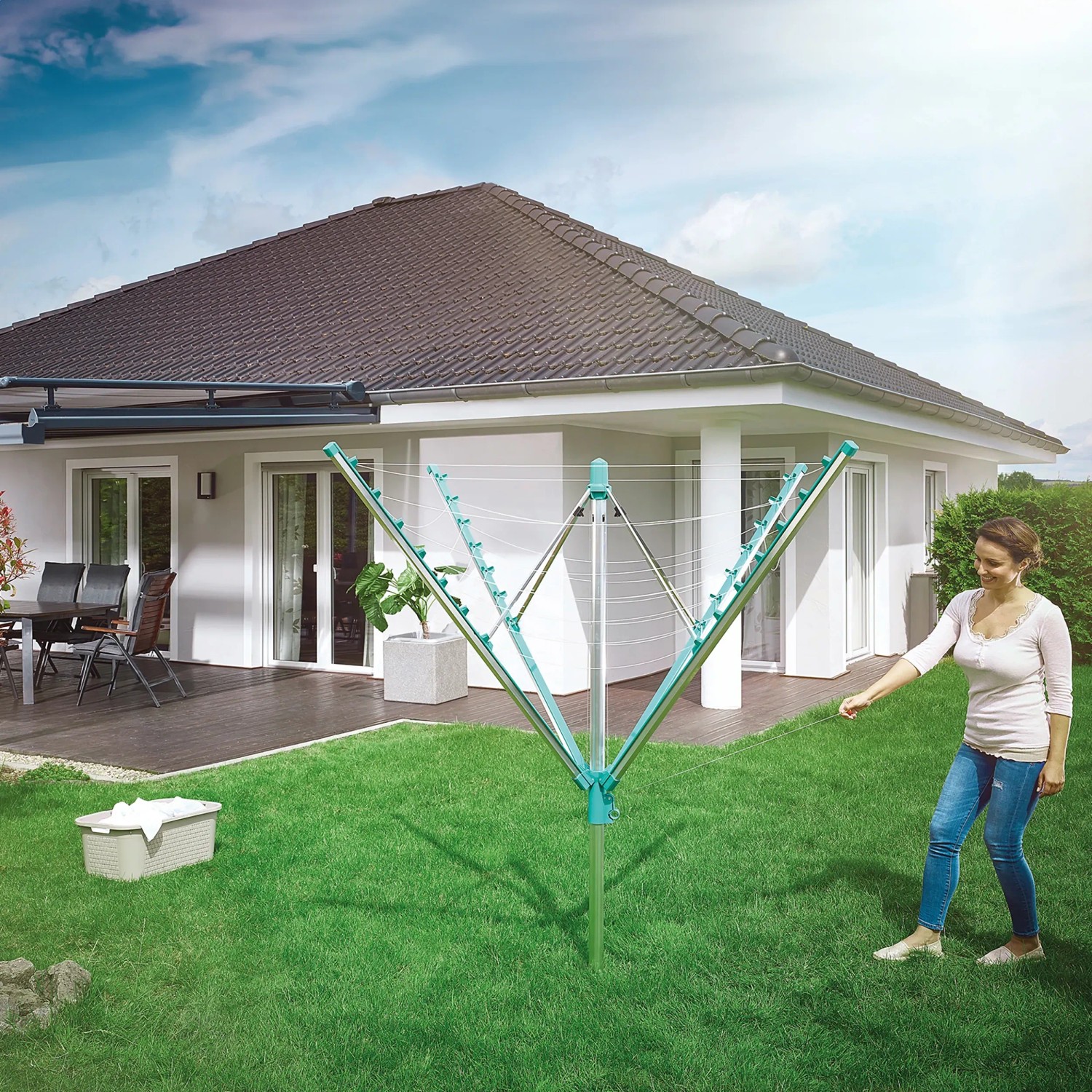 Geöffnete Leifheit Wäschespinne Linomatic 400 Easy im Garten mit Frau und Wäschekorb.