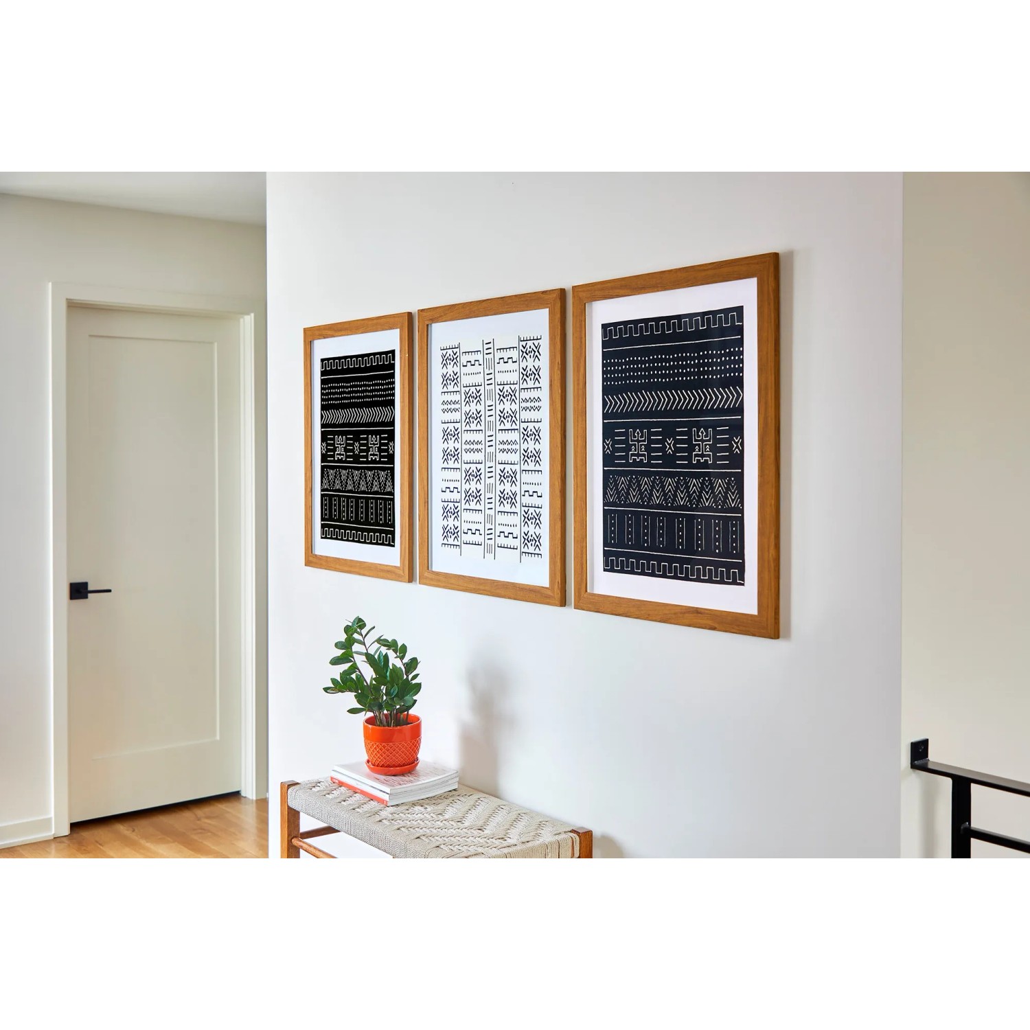 Drei gerahmte Bilder mit Mustern an Wand befestigt mit Command Bilder-Montage-Strips.