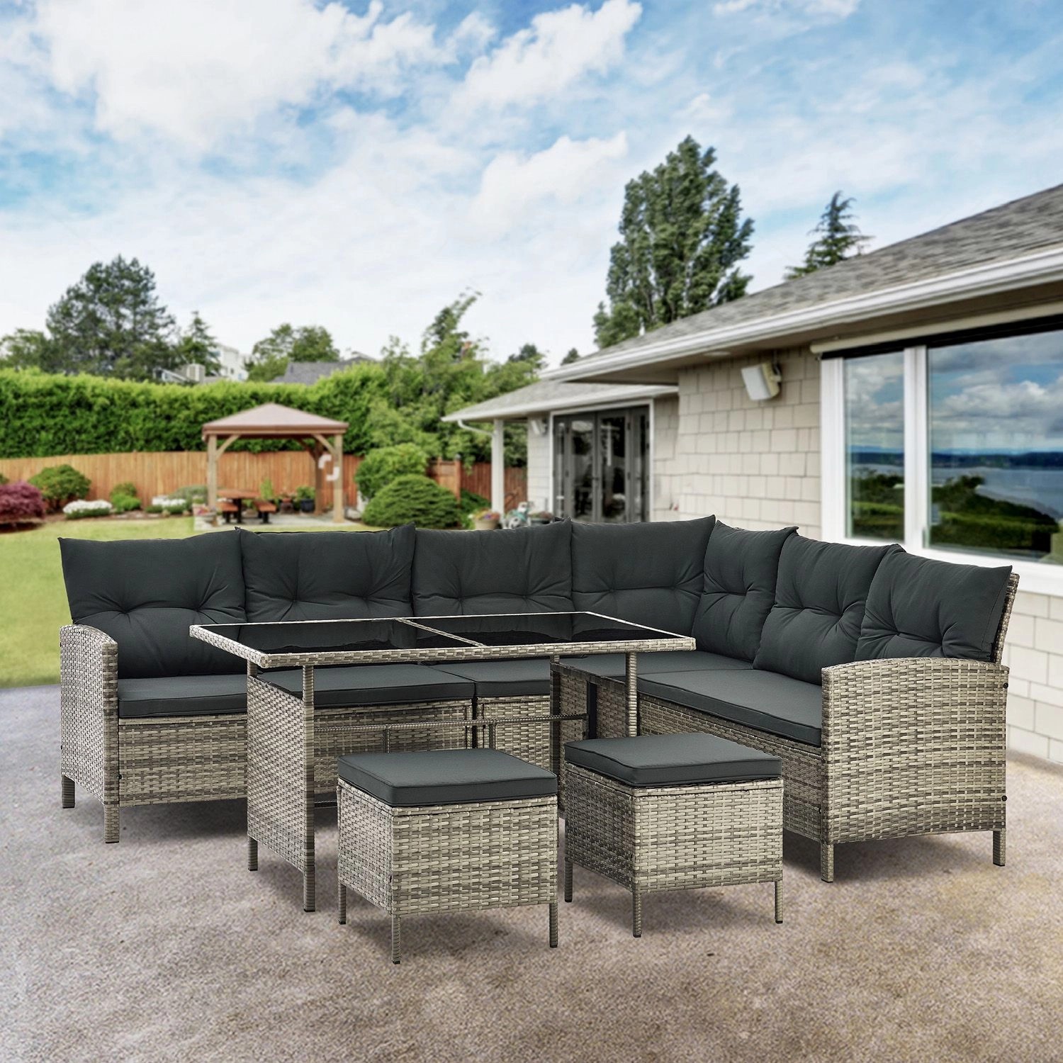 Grau melierte Polyrattan Gartenlounge Manacor mit dunkelgrauen Bezügen, Tisch und Hockern.