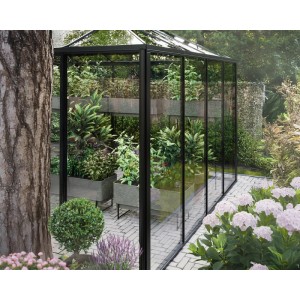 Schwarzes Bloomcabin Aluminium-Pyramidengewächshaus mit Glaswänden, gefüllt mit Pflanzen, in einem modernen Garten.