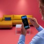 Mann steuert WIZ Deckenleuchte Imageo per App im Wohnzimmer.