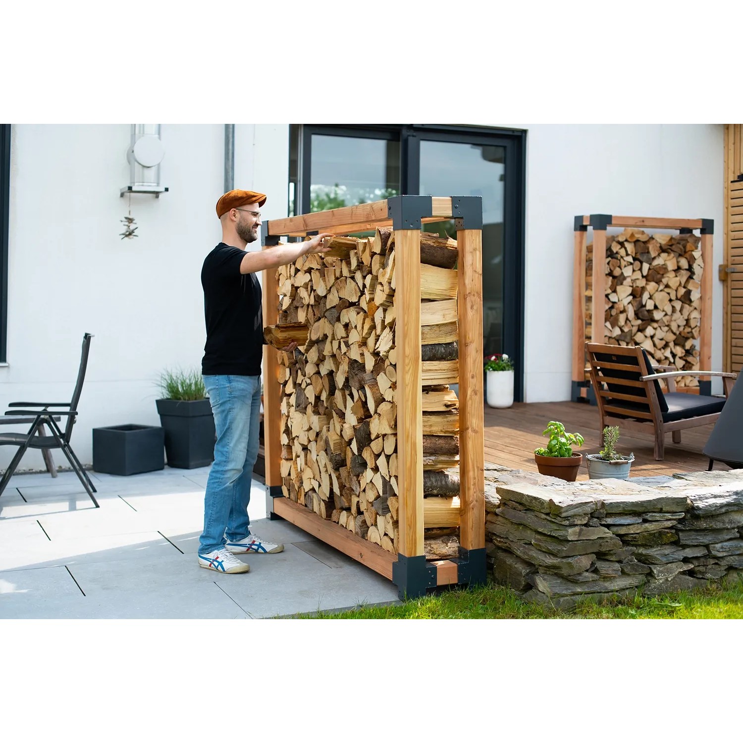 Westmann Lärchenholz Kaminholzregal Michel XXL FSC® mit Holzscheiten im Garten.