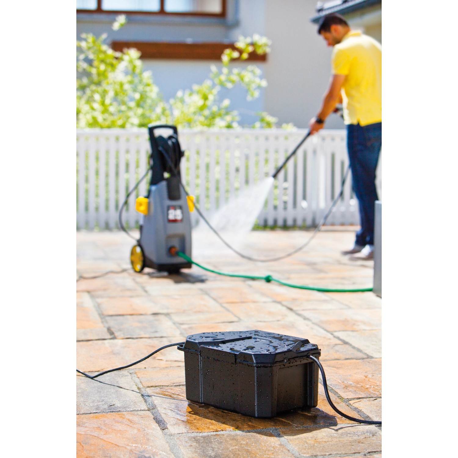 Schwarze Heissner Garden Power Box für Teichpumpen und Filter im Garten mit Hochdruckreiniger.