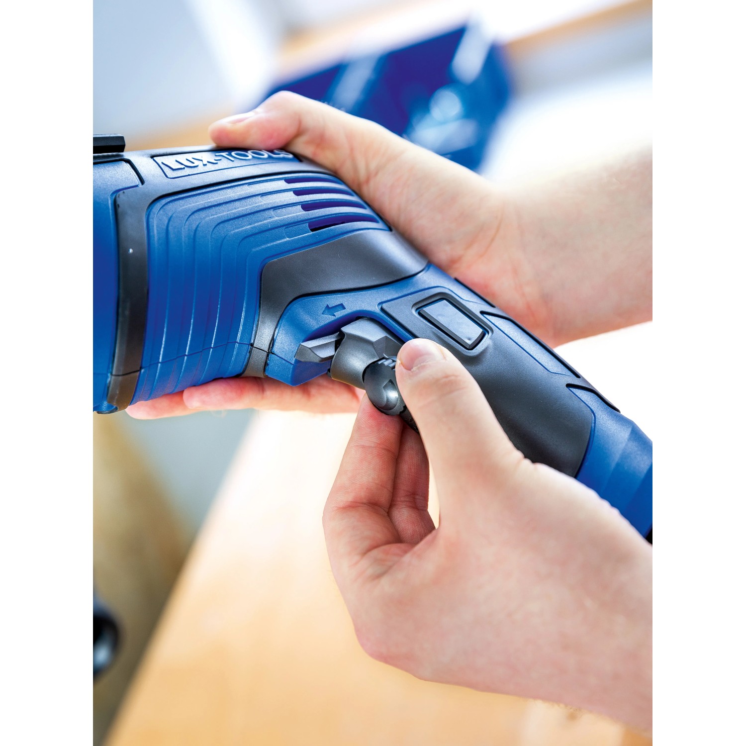 Nahaufnahme: Hände bedienen blaue LUX Schlagbohrmaschine E-BMS-21 mit Tiefenanschlag.