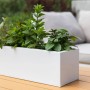 Weißer Vivanno Pflanzkasten Flobo 45 cm mit Bepflanzung auf einem Gartentisch.