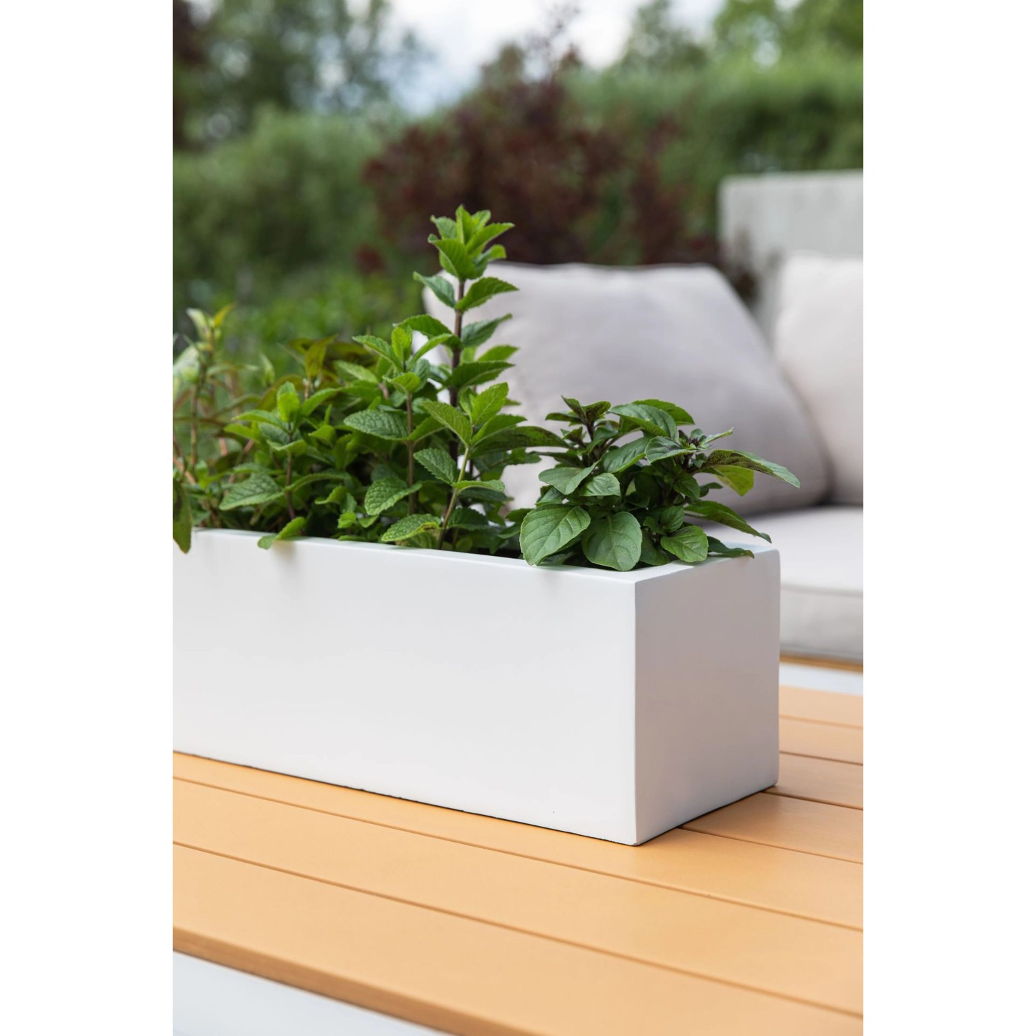 Weißer Vivanno Pflanzkasten Flobo 45 cm mit Bepflanzung auf einem Gartentisch.