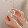 Montage des schwarzen, matten Tesa Toilettenpapierhalters Moon mit Klebelösung an der Wand.