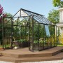 Schwarzes Vitavia Gewächshaus Olymp 8300 ESG mit Glasfront auf Holzterrasse im Garten.