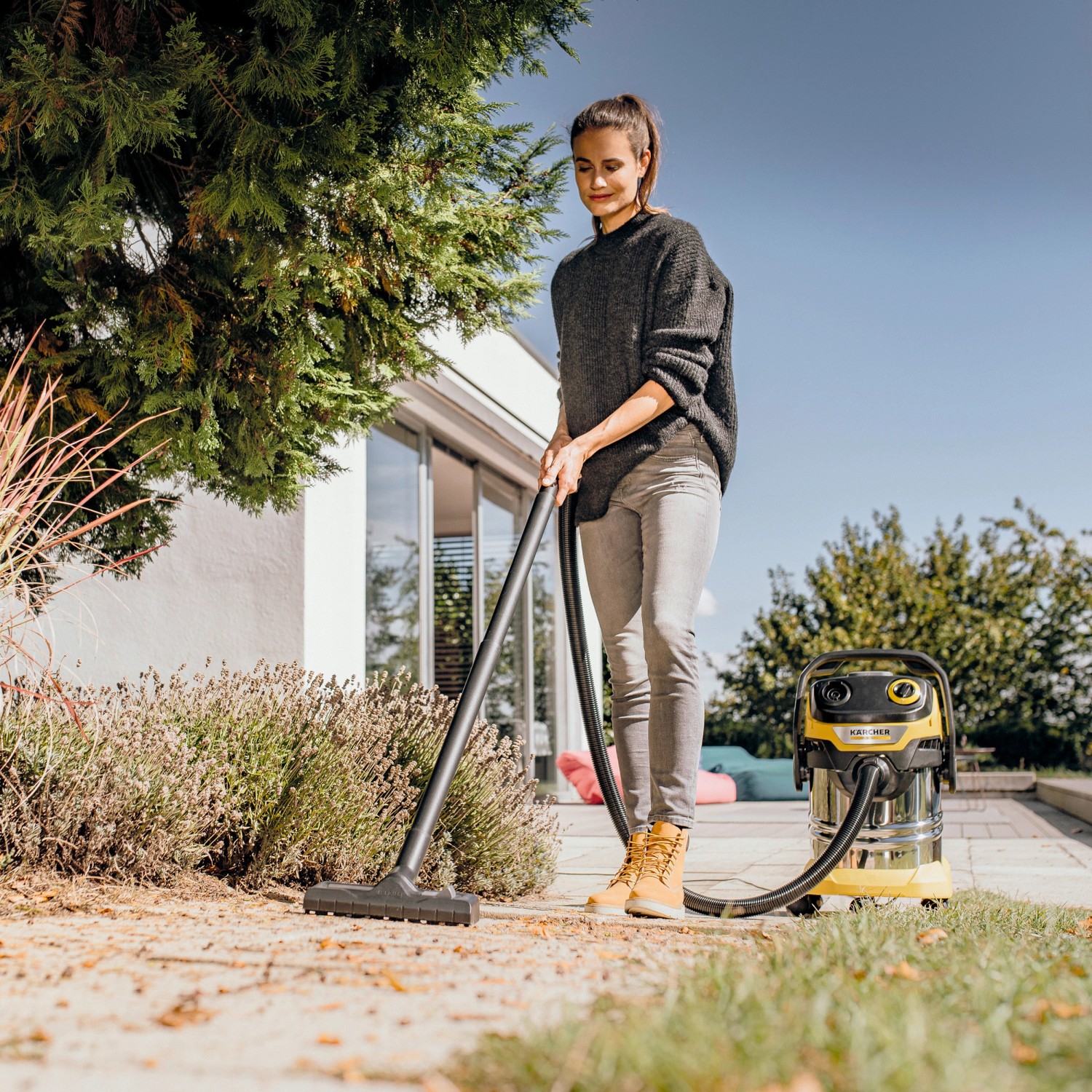 Frau nutzt Kärcher WD 5 S V-25/5/22 Nass-/Trockensauger im Garten.